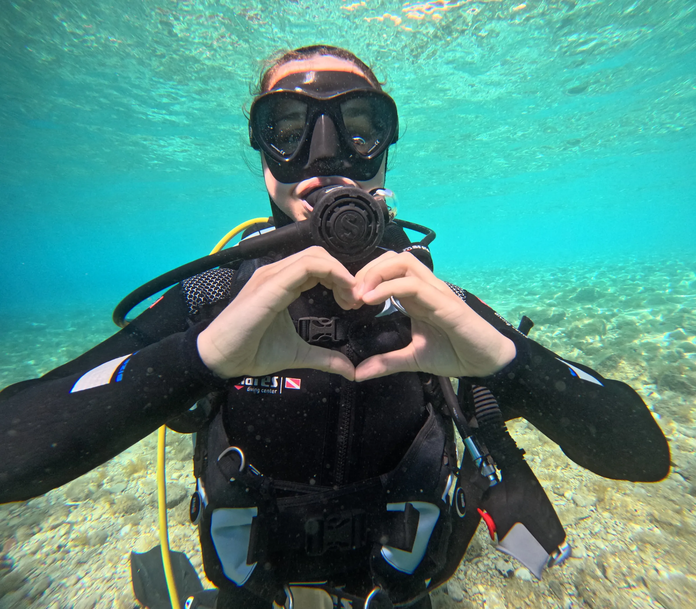 Diver forming a heart with her hands underwater in Split